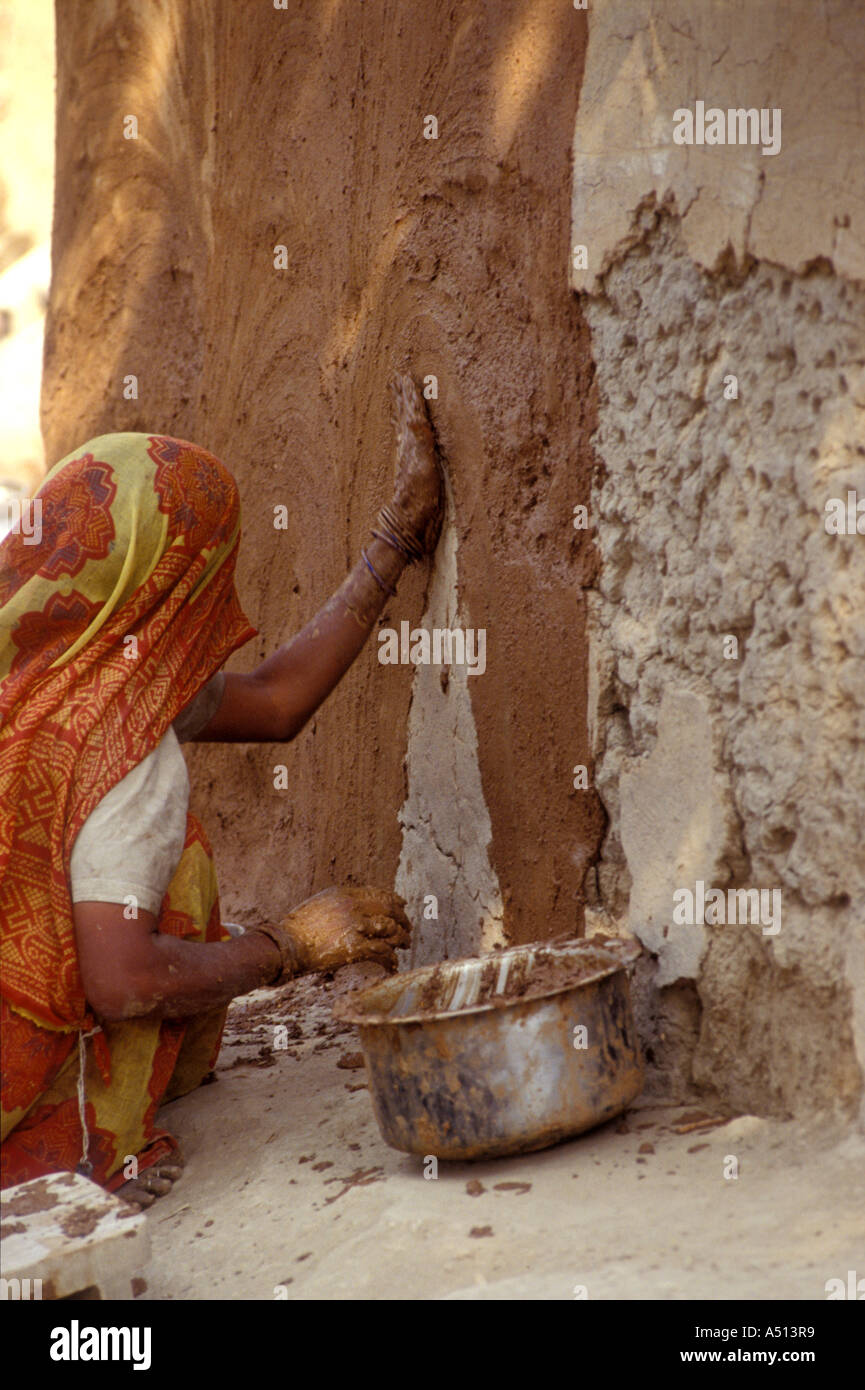 Donna Applicazione di fango sulle pareti di una capanna Bharatpur Rajasthan in India Foto Stock