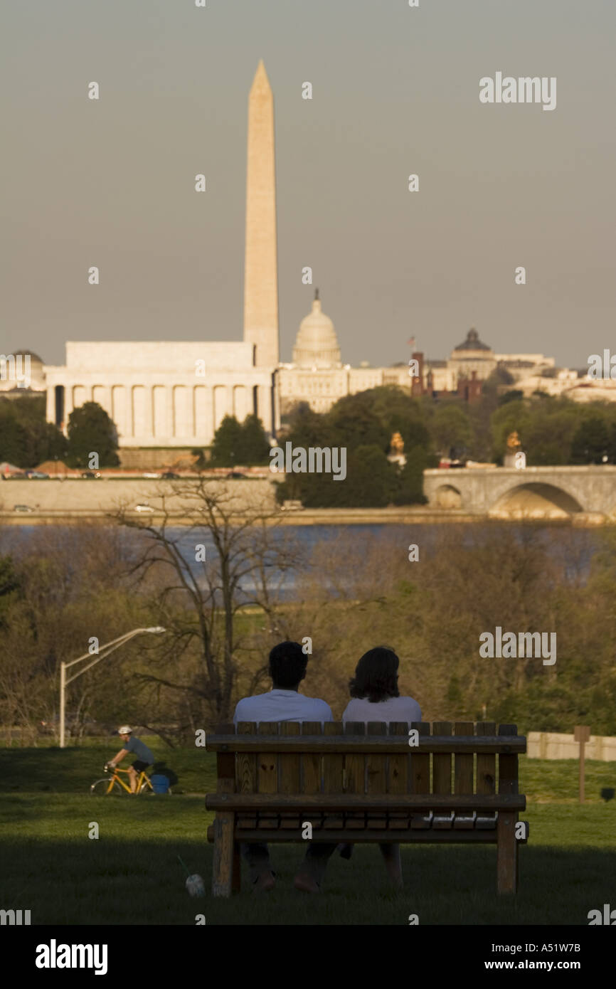 Coppia seduta sul banco di lavoro con il Lincoln Memorial il Monumento a Washington e il Campidoglio di distanza da Arlington Virginia STATI UNITI D'AMERICA Foto Stock