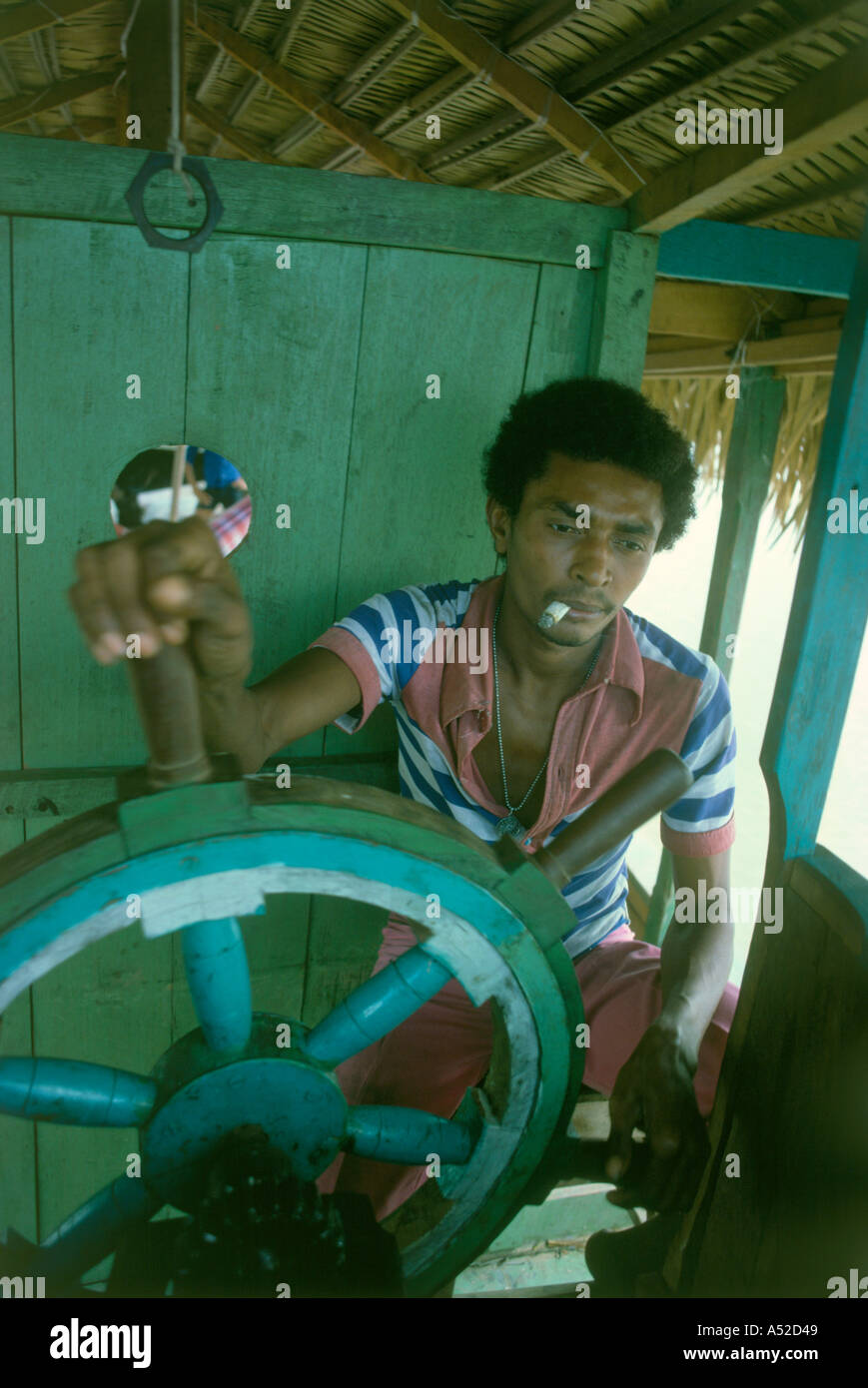 Caboclo sangue miscelato persona rurale al timone della barca sul fiume regione amazzonica del Brasile Foto Stock