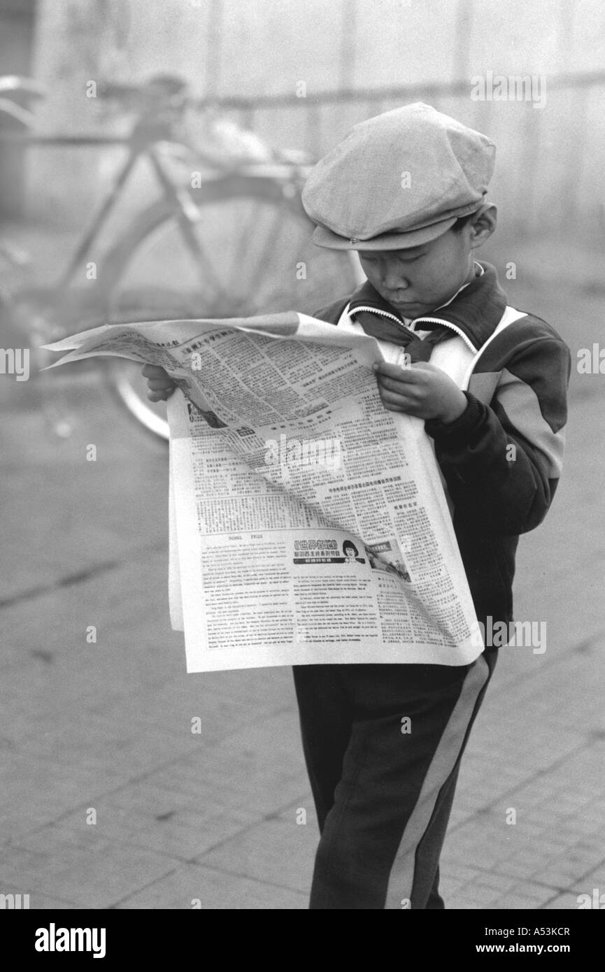 Painet ha1247 025 in bianco e nero media ragazzo lettura giornale Pechino Cina paese nazione in via di sviluppo economicamente più sviluppate Foto Stock
