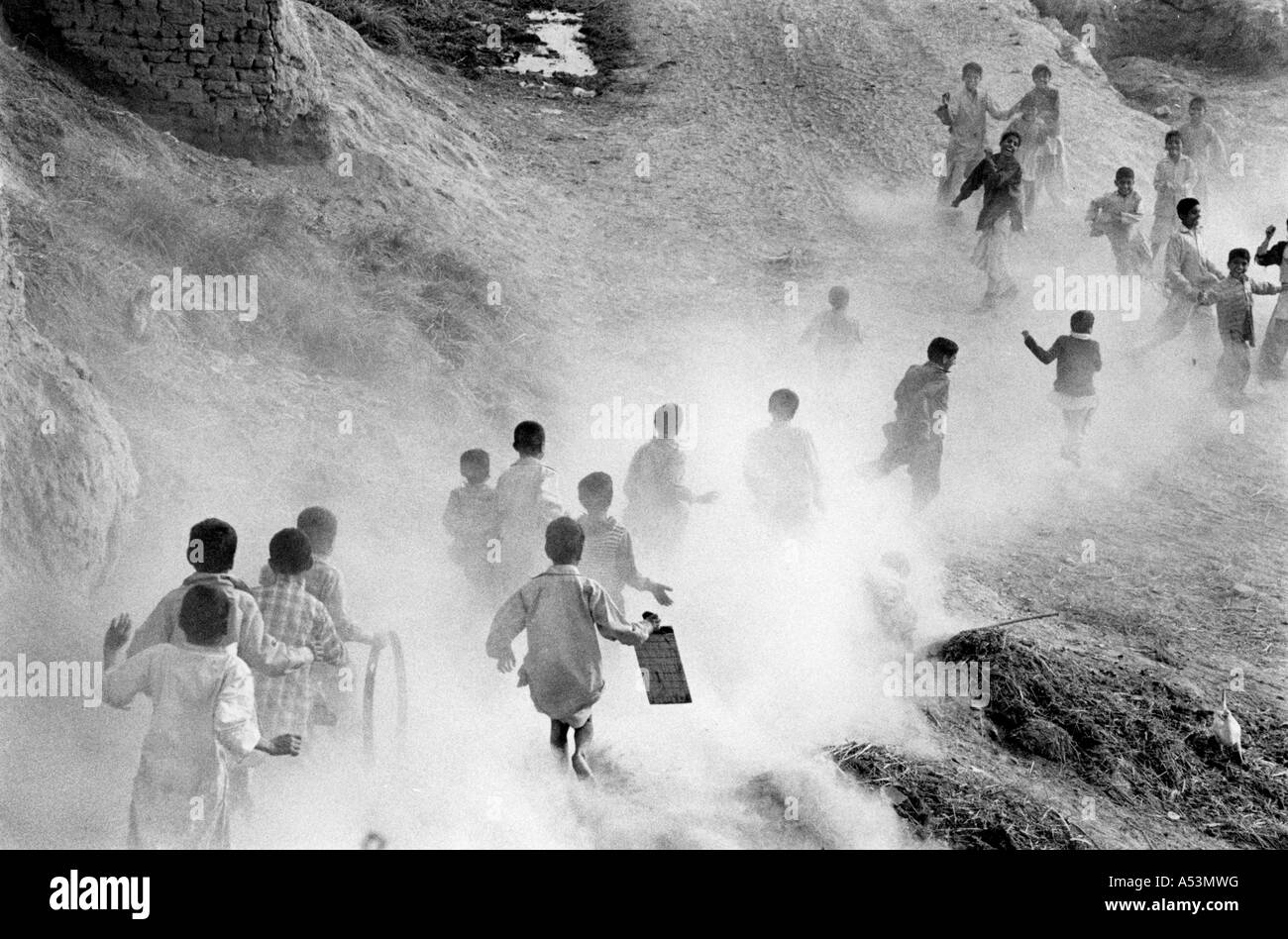 Painet ha1465 296 nero e bianco paesaggio boys sollevando la polvere run home school village punjab pakistan paese in via di sviluppo Foto Stock
