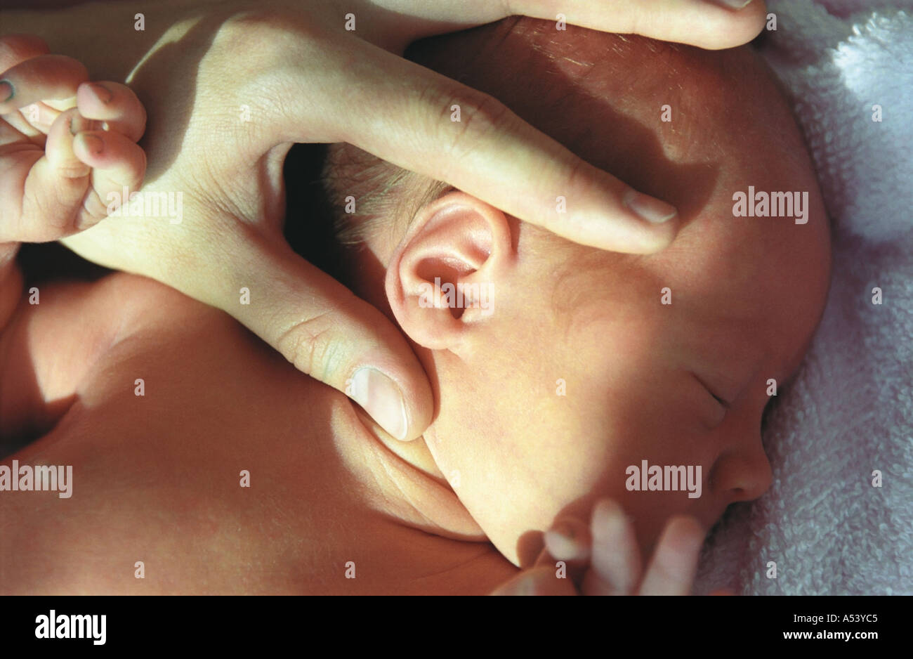 Un genitore misure un orecchio di un neonato in Russia Foto Stock