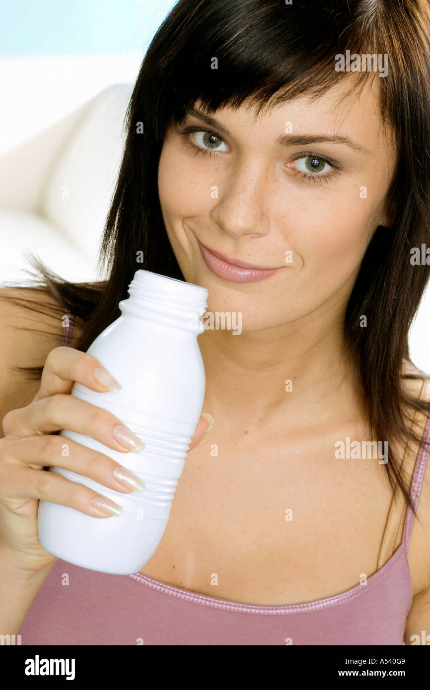 Giovane donna con una bottiglia di yogurt da bere Foto Stock