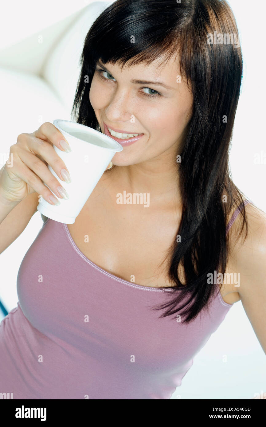 Giovane donna con un bicchiere di yogurt da bere Foto Stock