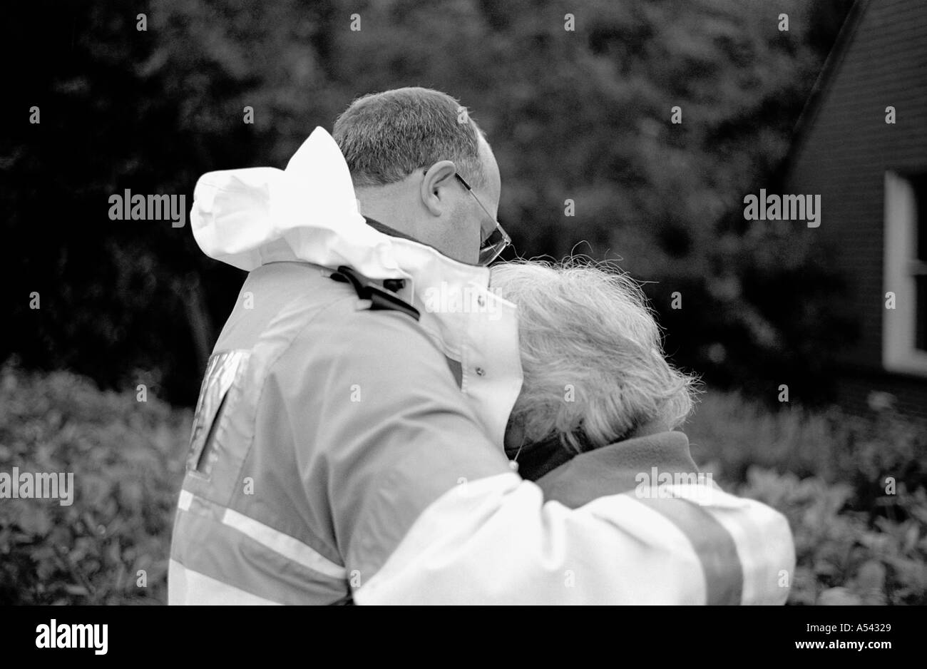 Paramedic consolante sconvolto anziana signora dopo il suo salvataggio dai vigili del fuoco a Lewes inondazioni East Sussex Regno Unito 2000 Foto Stock