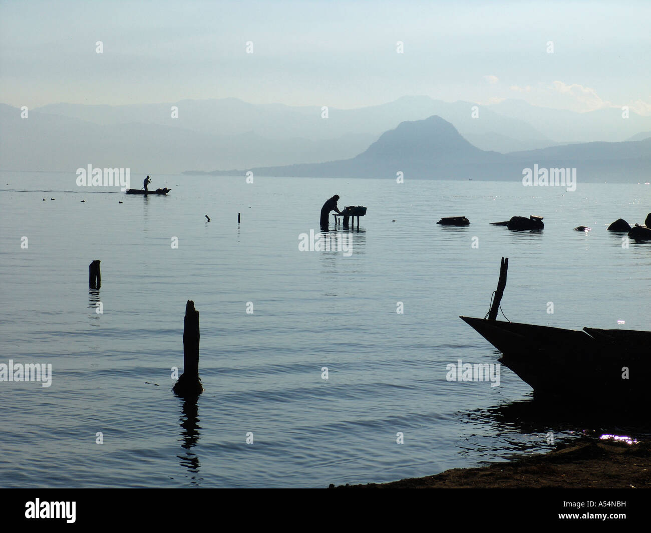 Ip Painet1684 guatemala donna lavando vestiti lago Atitlan san pedro uomo pagaie passato canoa paese nazione in via di sviluppo meno Foto Stock