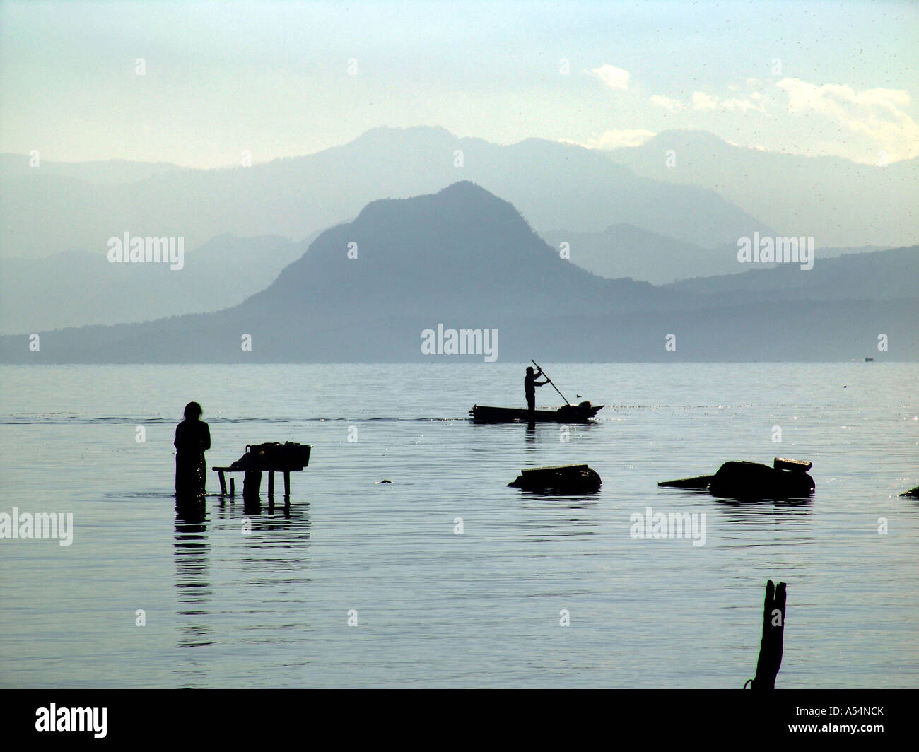 Ip Painet1688 guatemala donna lavando vestiti lago Atitlan san pedro uomo pagaie passato canoa paese nazione in via di sviluppo meno Foto Stock