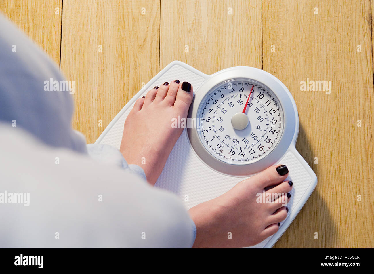 Donna in piedi sulle bilance Foto Stock