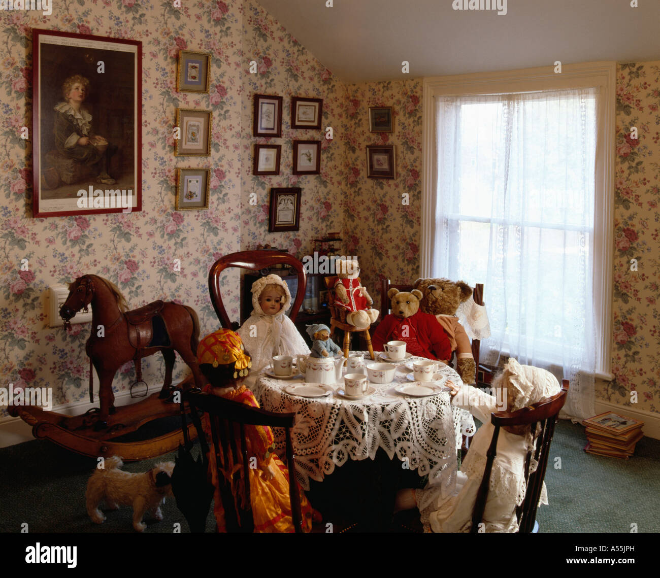 Bambola teaparty nel periodo Vittoriano sala da pranzo con carta da parati floreale Foto Stock