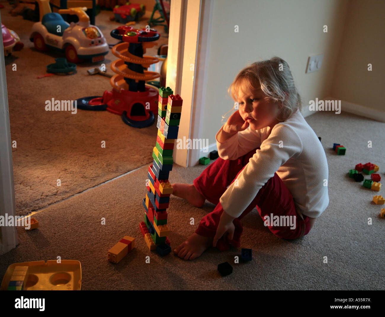 Ragazza giovane frustrato giocando con lego in home Foto Stock