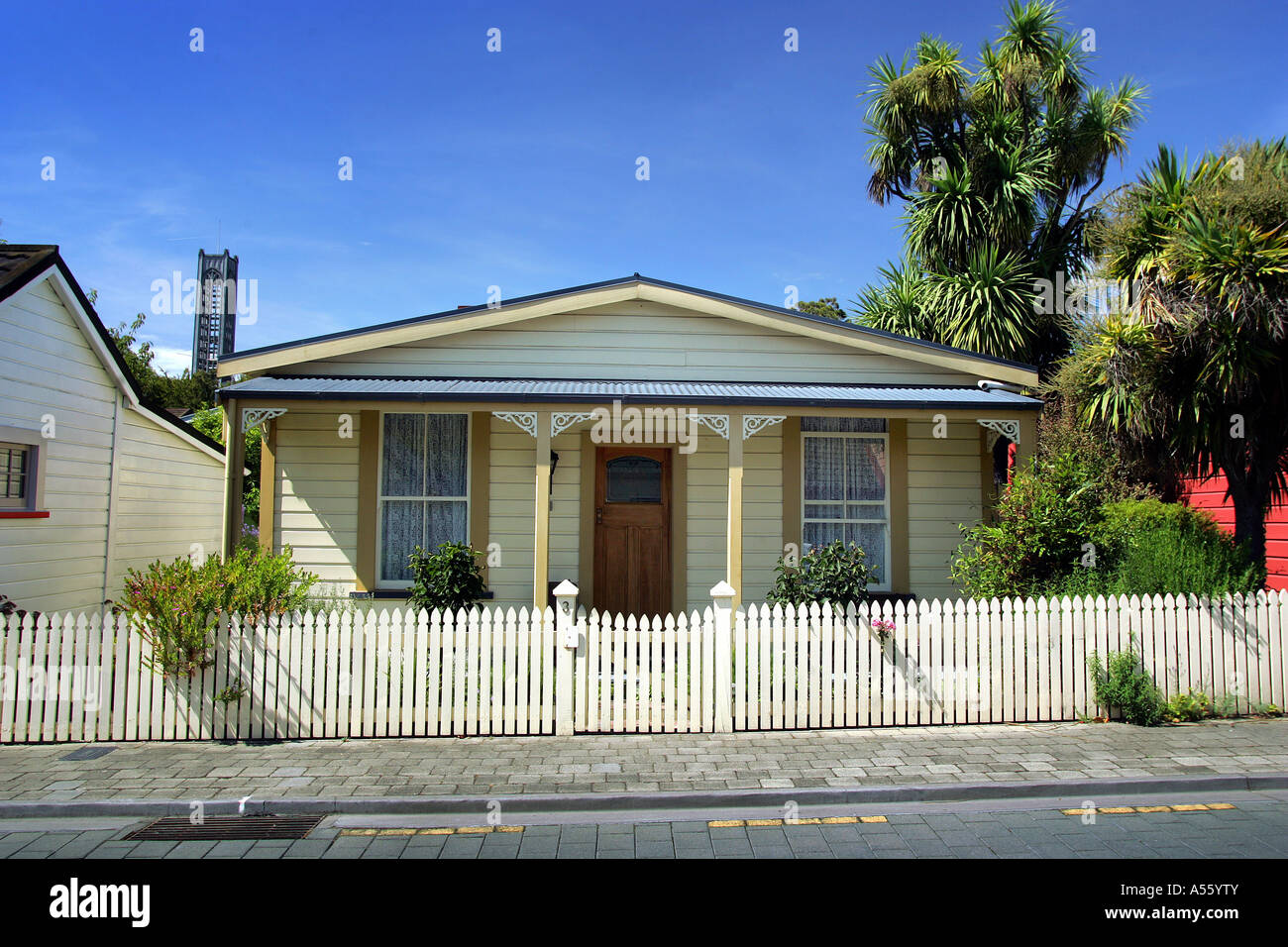 Un bungalow nella storica città di South Street nella città di Nelson Nuova Zelanda con la torre della cattedrale nella parte posteriore sinistra della foto Foto Stock