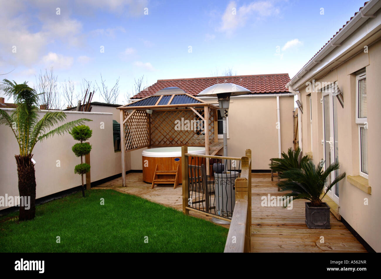 Un giardino sul retro con un decking area e vasca calda REGNO UNITO Foto Stock