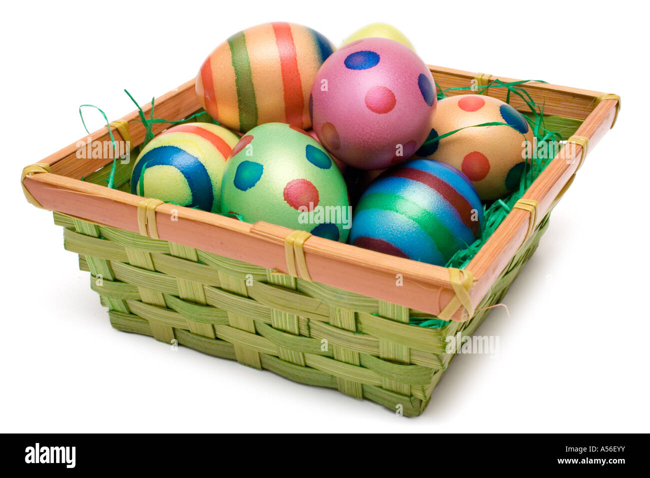 Colorate le uova di Pasqua in un cesto tessuto. Isolato su uno sfondo bianco. Foto Stock