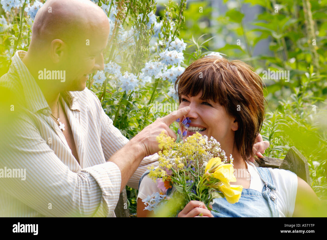 Matura in giardino con donna holding mazzo di fiori Foto Stock