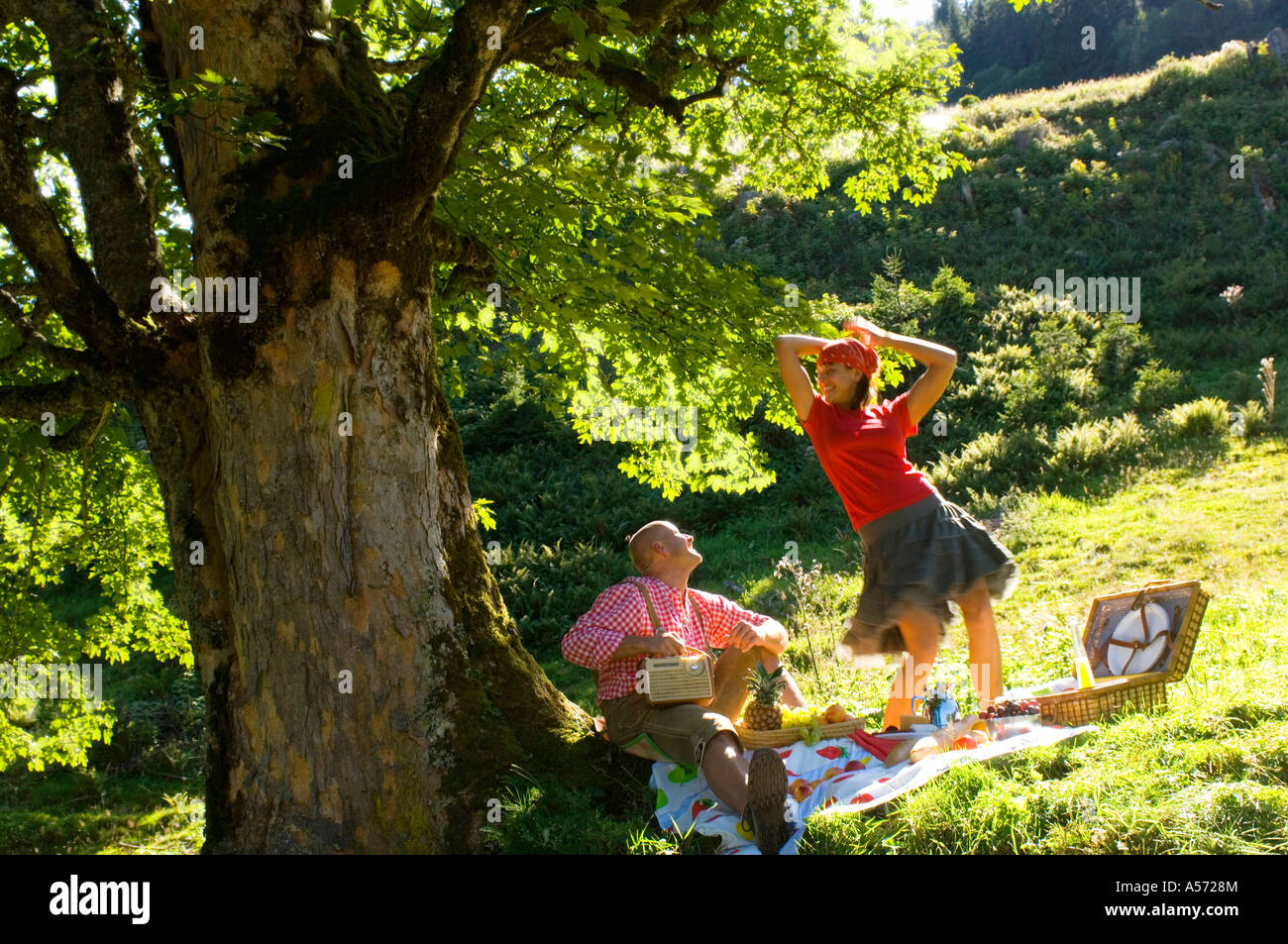 Giovane avente picnic sotto agli alberi, woman dancing Foto Stock