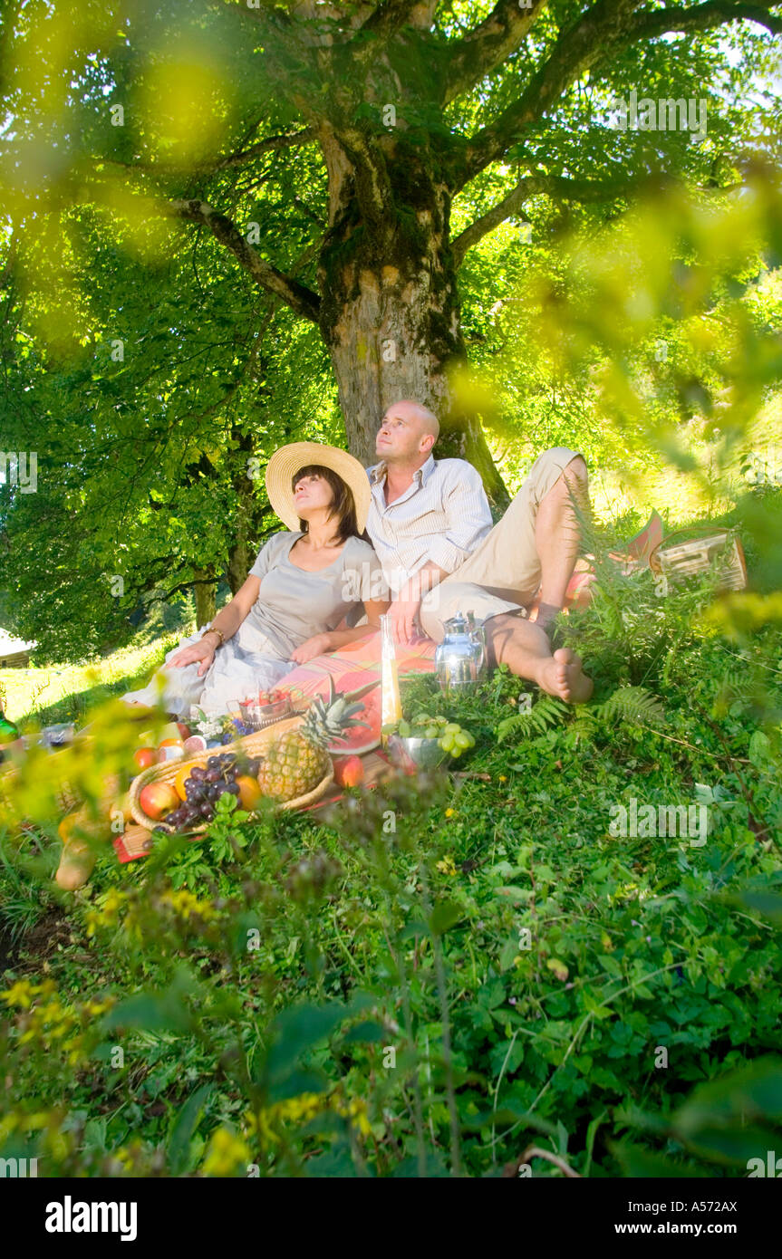 Giovane avente picnic sotto agli alberi Foto Stock