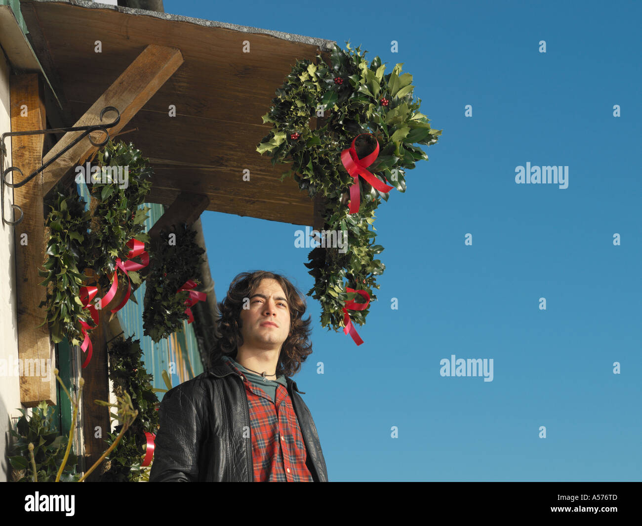 Giovane con natale decorazioni naturali al di fuori contro il cielo blu Foto Stock