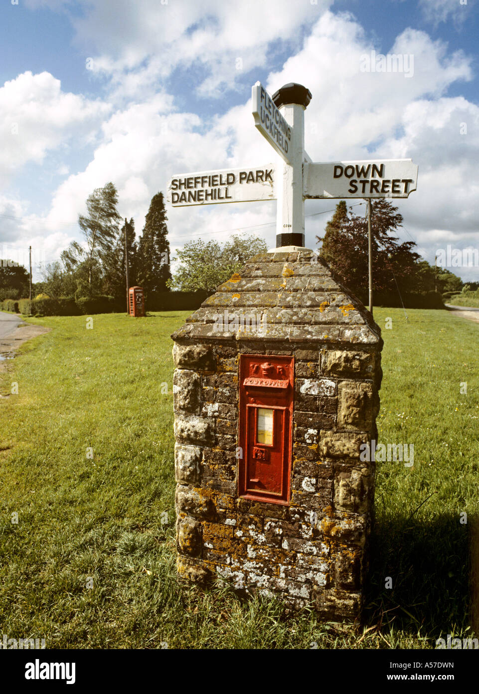 Regno Unito East Sussex Fletching K6 casella Telefono sul verde villaggio al di là di insolita cum signpost casella postale Foto Stock