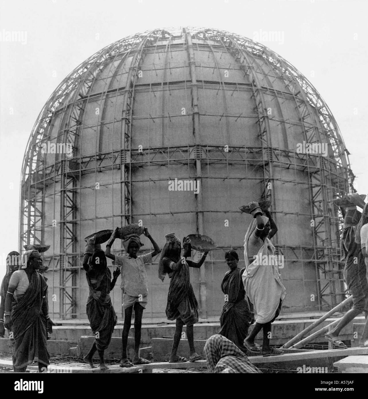 BARC - Bhabha Atomic Research Center sotto la costruzione da parte di uomini e donne che trasportano il materiale di costruzione sul loro capo, Bombay, Mumbai, India - 1900S Foto Stock