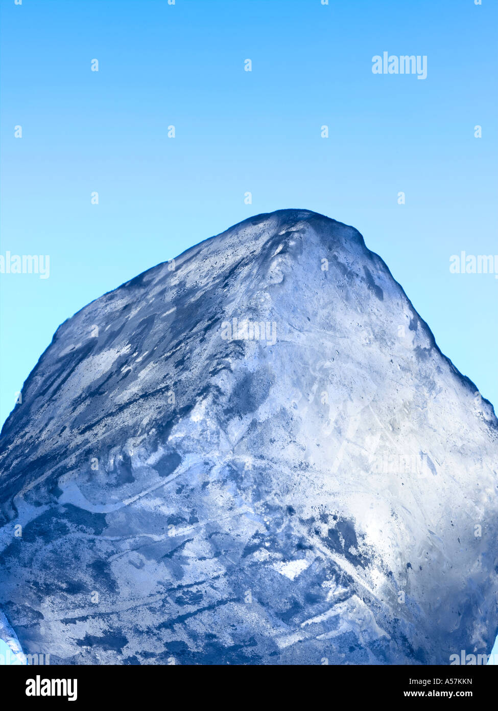 Un blocco di ghiaccio / cubo su un cielo blu sullo sfondo Foto Stock