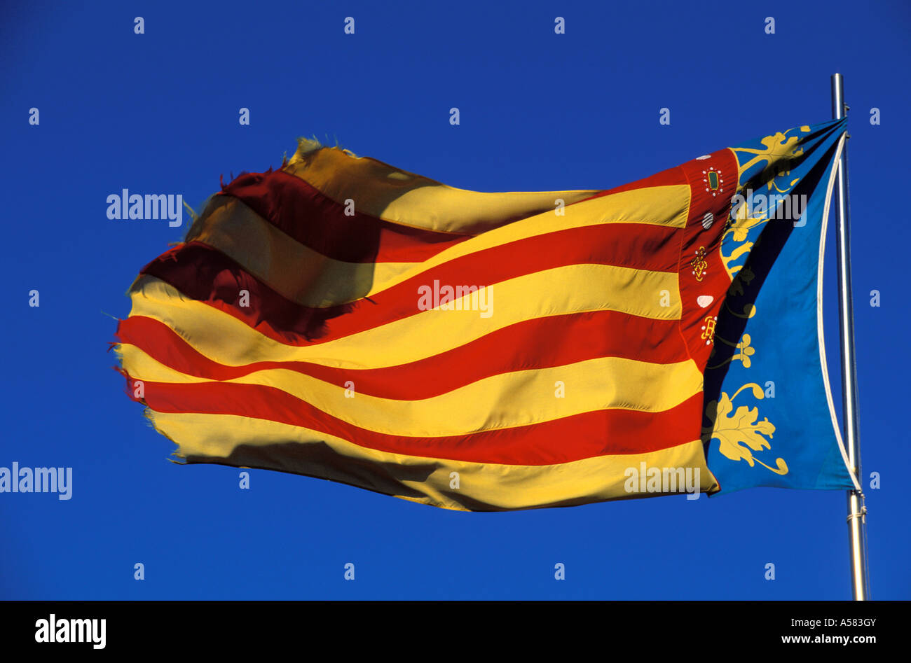 Bandiera Di Valencia, Spagna, Ondeggiando Nel Vento Davanti Ad Un Cielo Blu Isolato E Soleggiato Image133266146