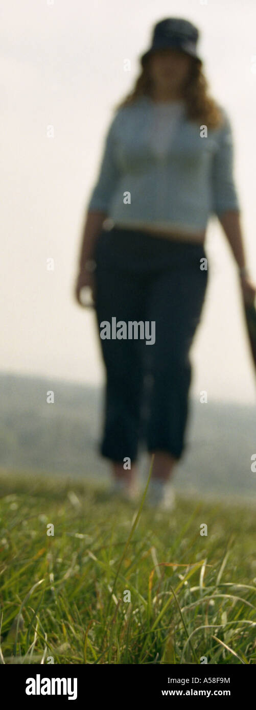 La figura di una giovane donna sull'erba. Foto Stock