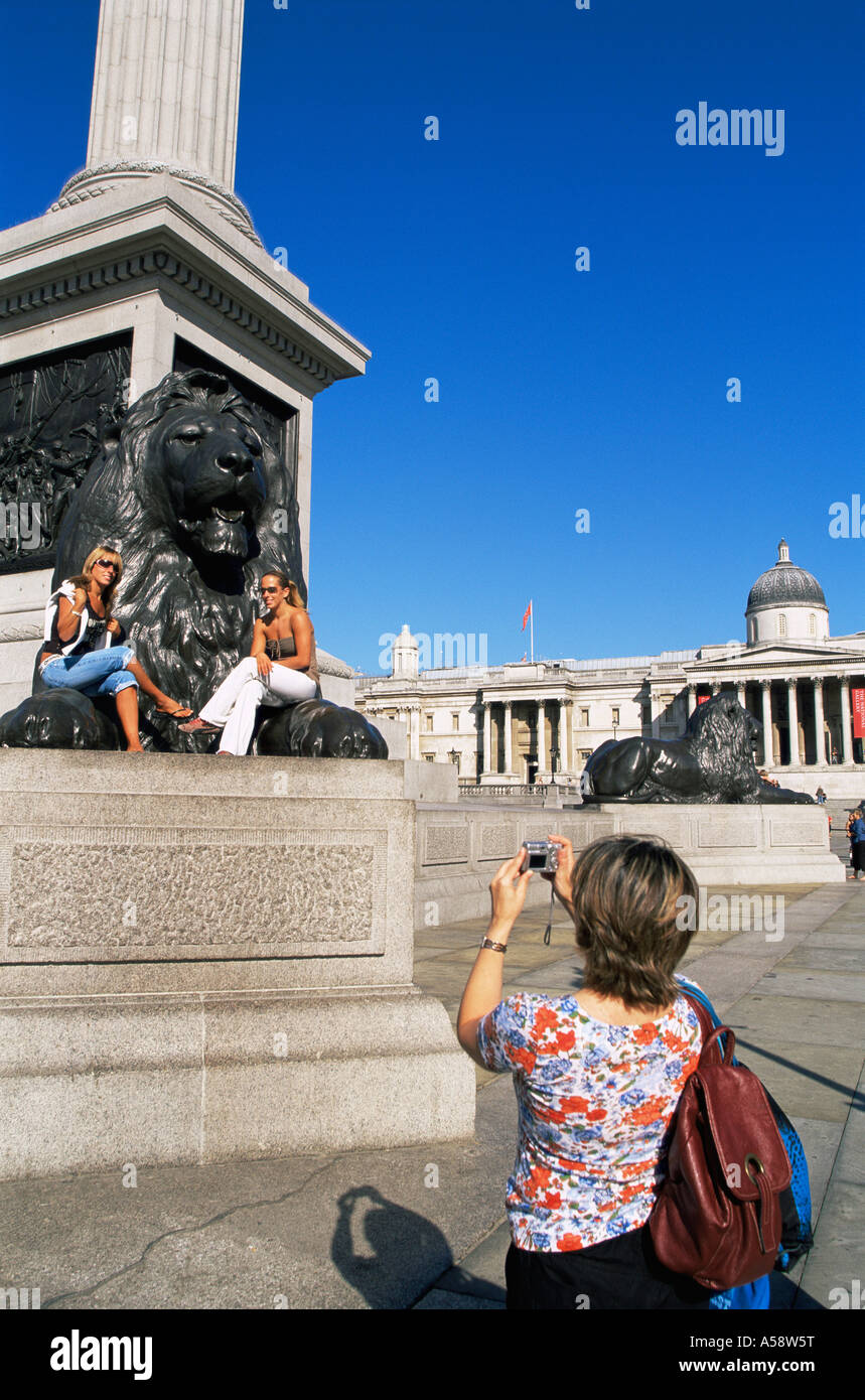 Inghilterra, Londra, Trafalgar Square, Femmina turisti prendendo foto ricordo sotto Nelsons Column Foto Stock