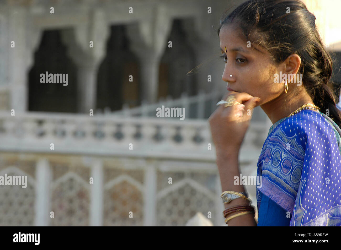 Momenti emozionali, contemplazione al Red Fort in Agra come una bella signora indiana sguardi sul Taj Mahal Foto Stock