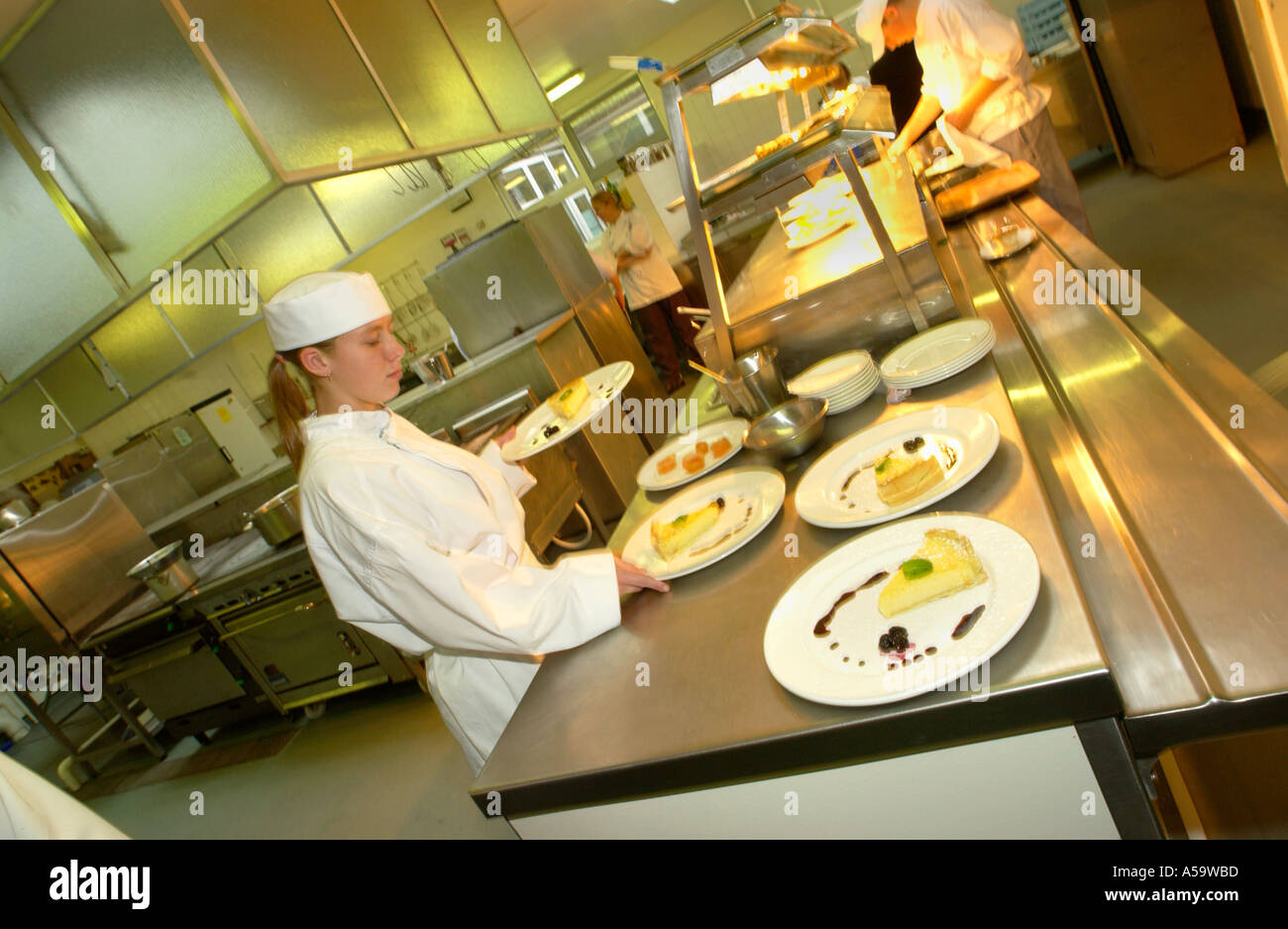 Studente chef preparare cibo sotto pressione di servizio ristorante a Neath Port Talbot College Wales UK Foto Stock