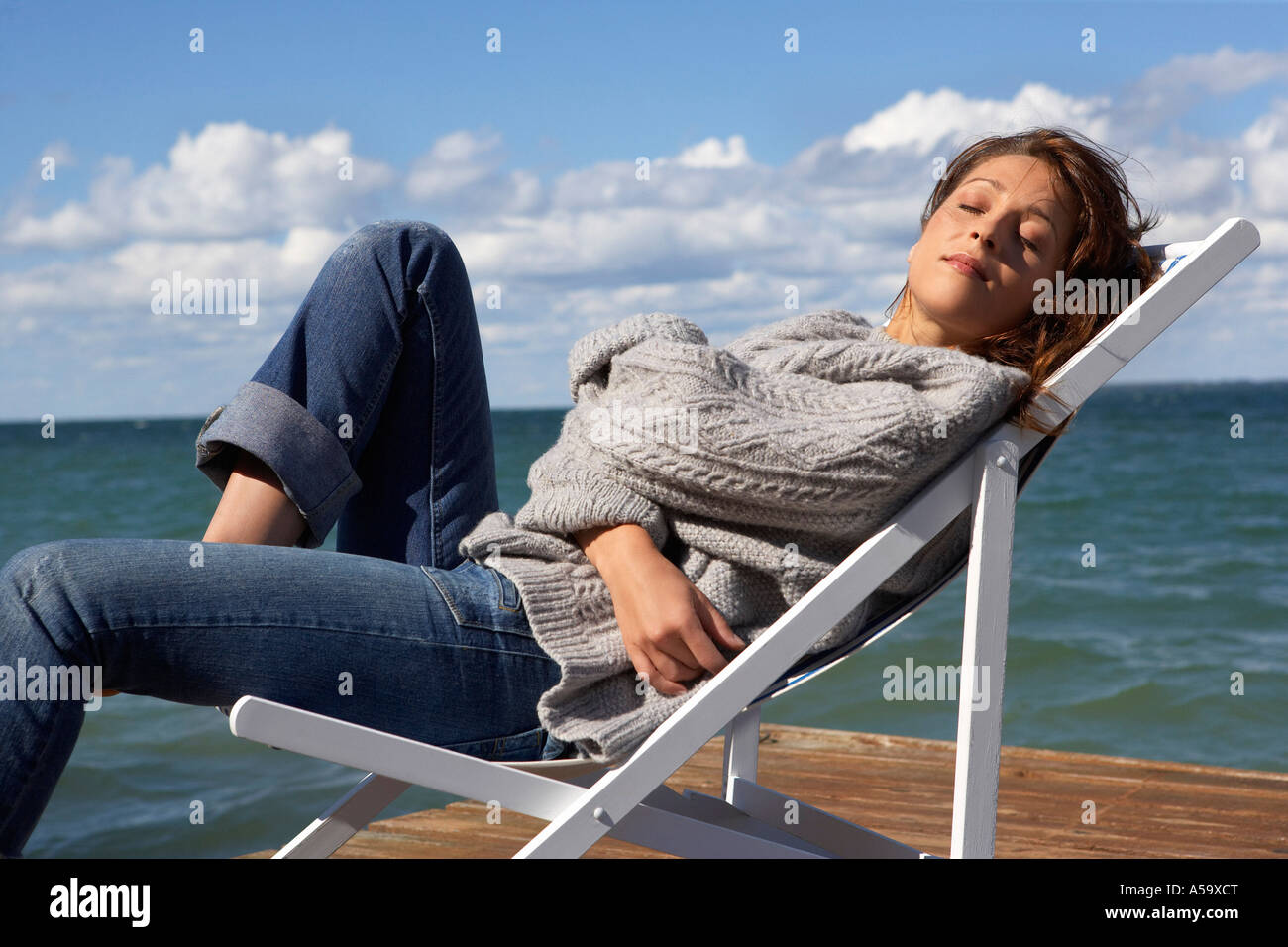 Donna in sedia pieghevole sul Dock Foto Stock