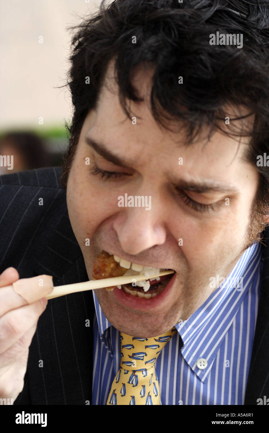 Avvocato aziendale e American expat mangiare il riso con bacchette, Hong Kong, Cina Foto Stock
