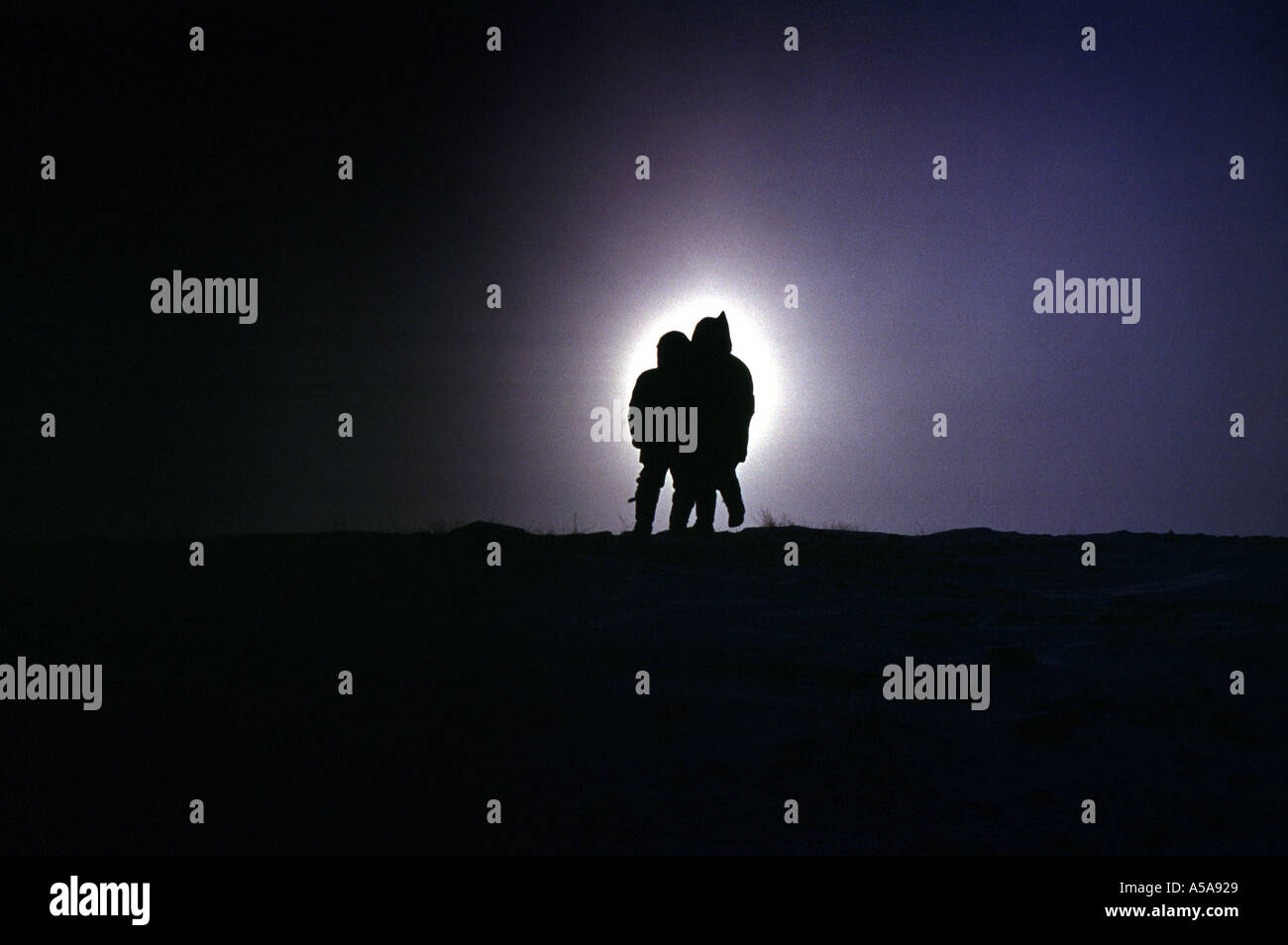 Due persone inuit nel Canadian grande nord contro un tramonto Foto Stock