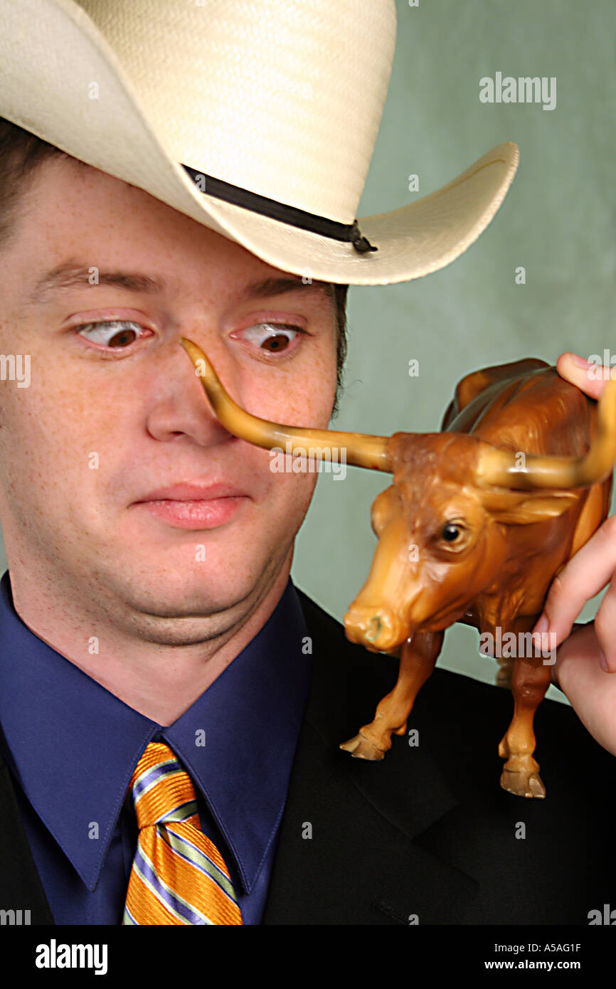 Ricchi Texas rancher in business suit holding longhorn figurina Foto Stock