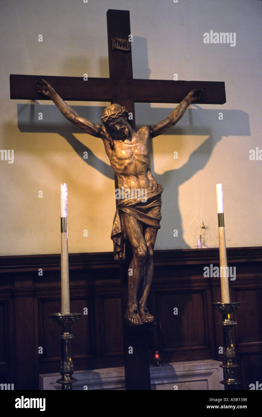 Statua di Cristo sulla croce su un lato altera in una chiesa Foto Stock