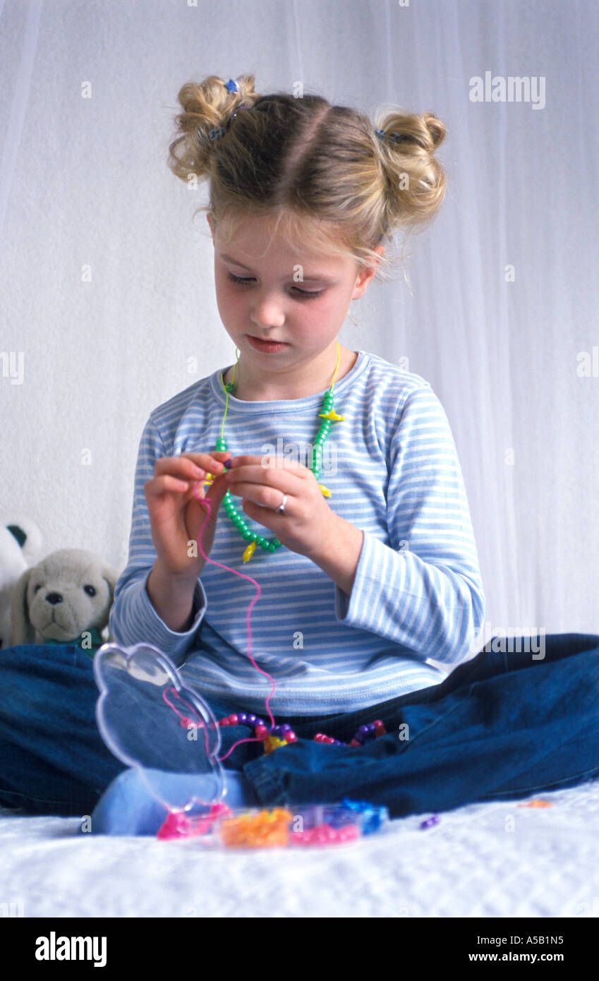 7 anno vecchia ragazza perline di stringhe Foto Stock