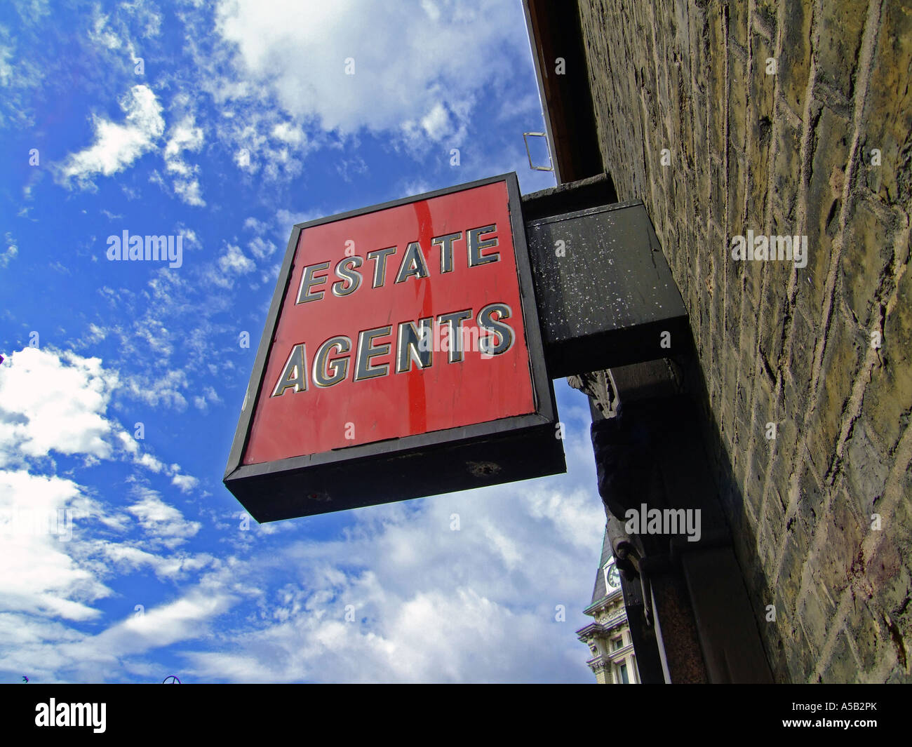 Rosso brillante Agenti Immobiliari segno contro il cielo blu. con copia spazio su tutti i lati Foto Stock