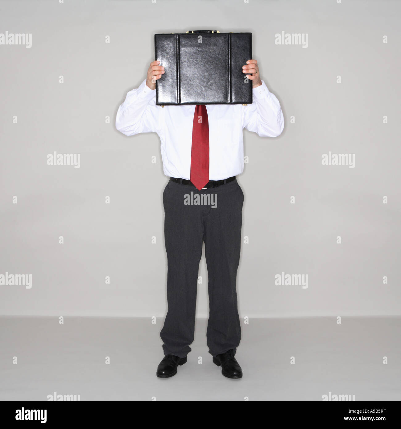 Imprenditore volto nascosto dietro la ventiquattrore. Foto Stock