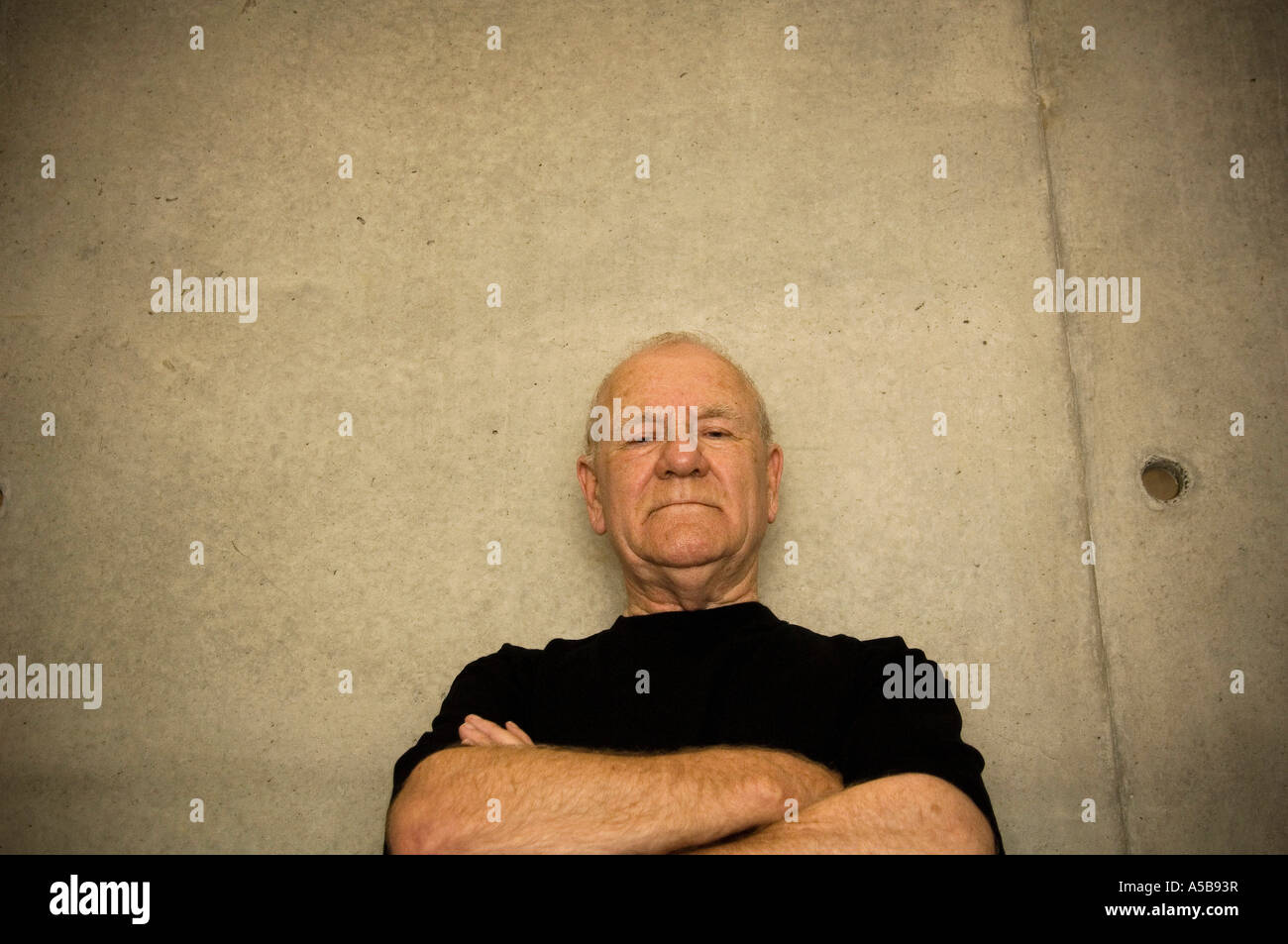 Vecchio Uomo intimidatorio i bracci piegatori. Foto Stock