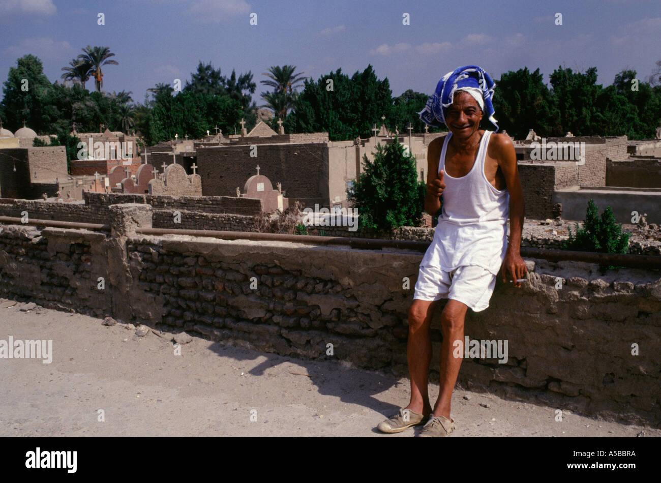 Un egiziano uomo seduto presso il cimitero cristiano complesso in Copto Cairo ( Masr al Qadima ) Il Cairo Egitto Foto Stock