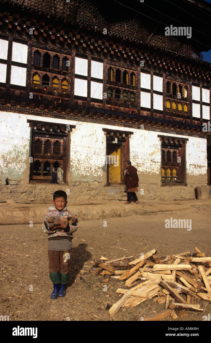 Ragazzo che trasportano cucciolo fuori monastero Buddista, Bhutan Foto Stock