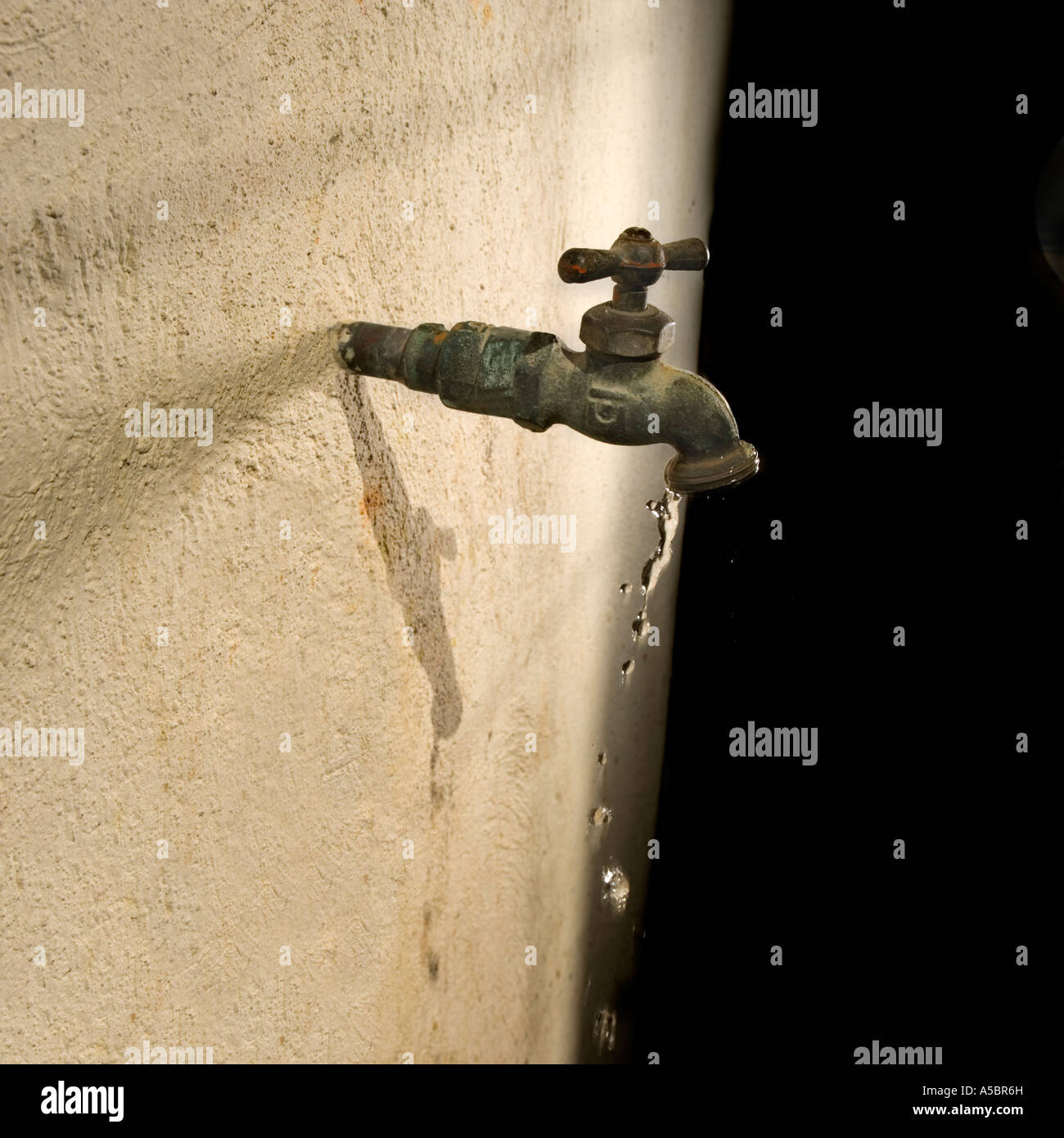 L'acqua che scorre dal rubinetto in ottone, penuria di conservazione e di razionamento, politico problema globale Foto Stock