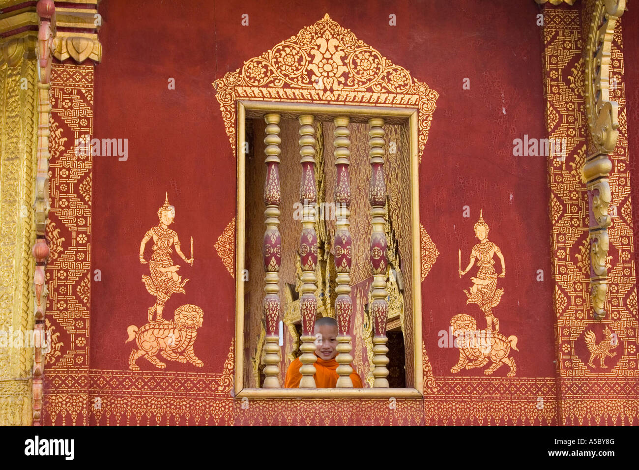 Monaco novizio attraverso la finestra del tempio Wat Saen Iva Sene Luang Prabang Laos Foto Stock