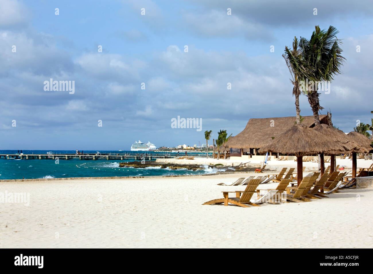 Spiaggia sabbiosa a Cozumel, Messico con ombrello con tetto di paglia di tabelle per i turisti Foto Stock