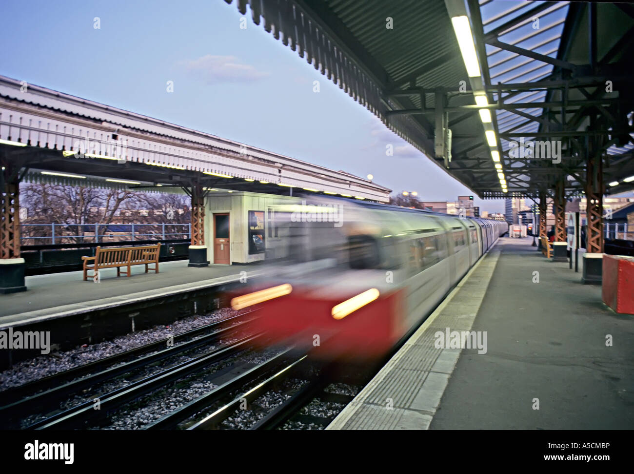 Treno accelerando attraverso la stazione ferroviaria REGNO UNITO Foto Stock