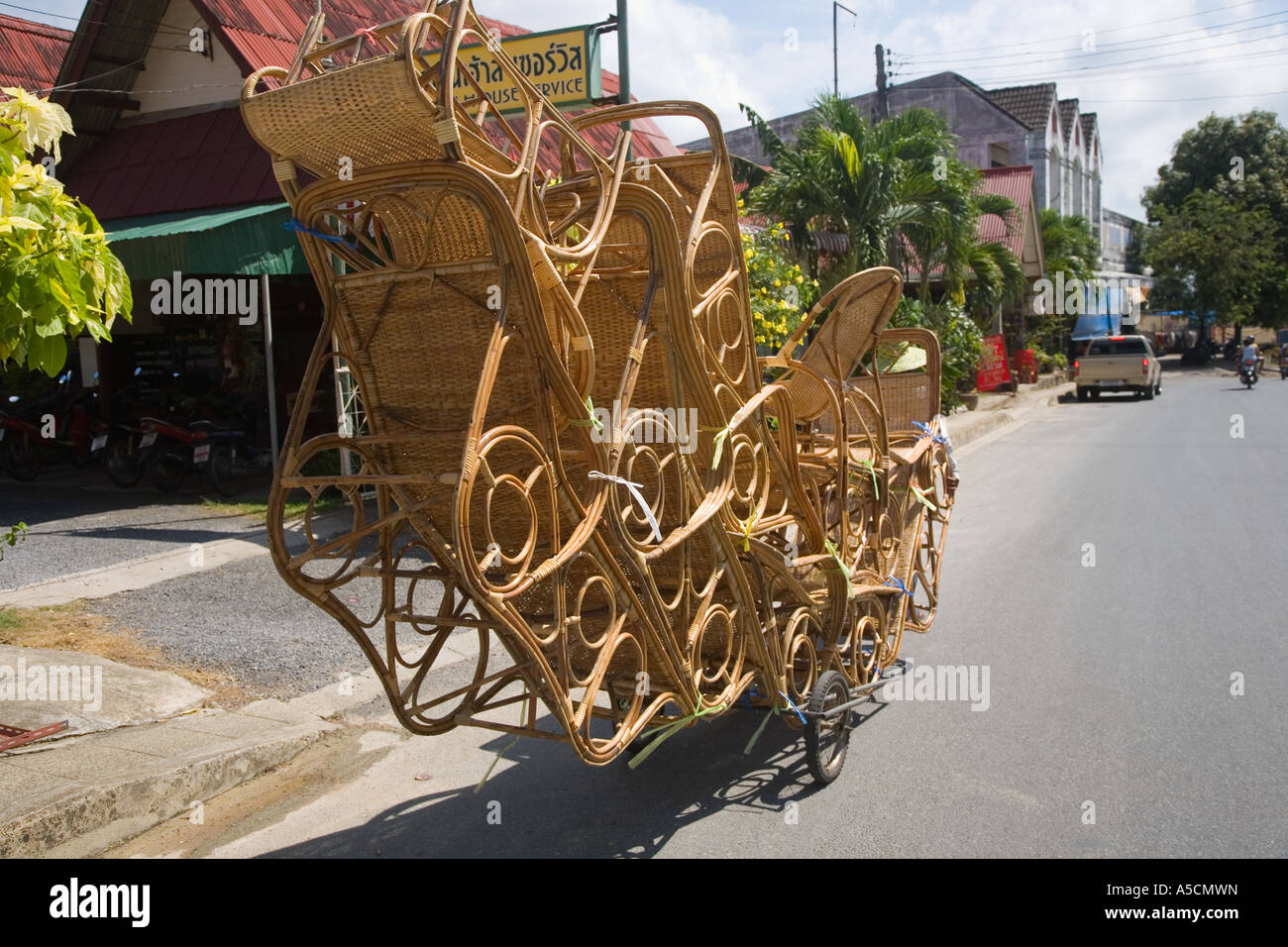 Thailandia venditore ambulante con un sovraccarico trasporto bicicletta artigianale di sedie di vimini, arredamento, design, natura, rattan artigianale di prodotti locali, in Asia. Foto Stock