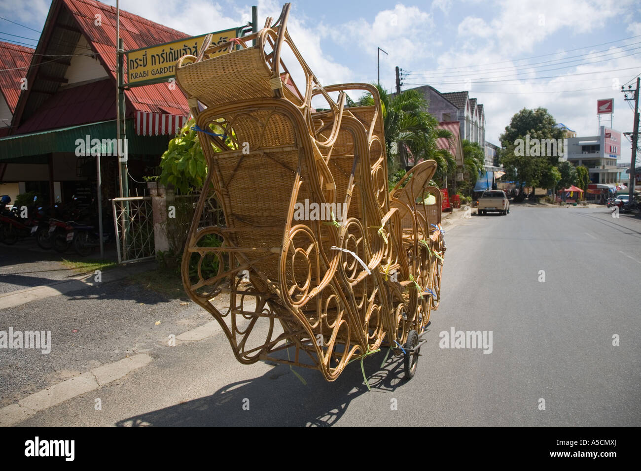 Thailandia venditore ambulante con un sovraccarico trasporto bicicletta artigianale di sedie di vimini, arredamento, design, natura, rattan artigianale di prodotti locali, Foto Stock