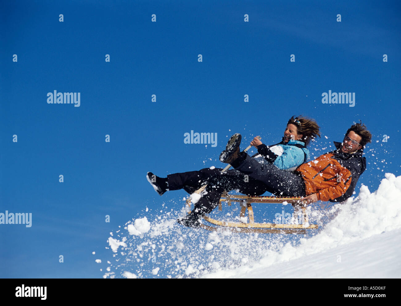 Coppia giovane sulla slitta jumping, vista laterale Foto Stock