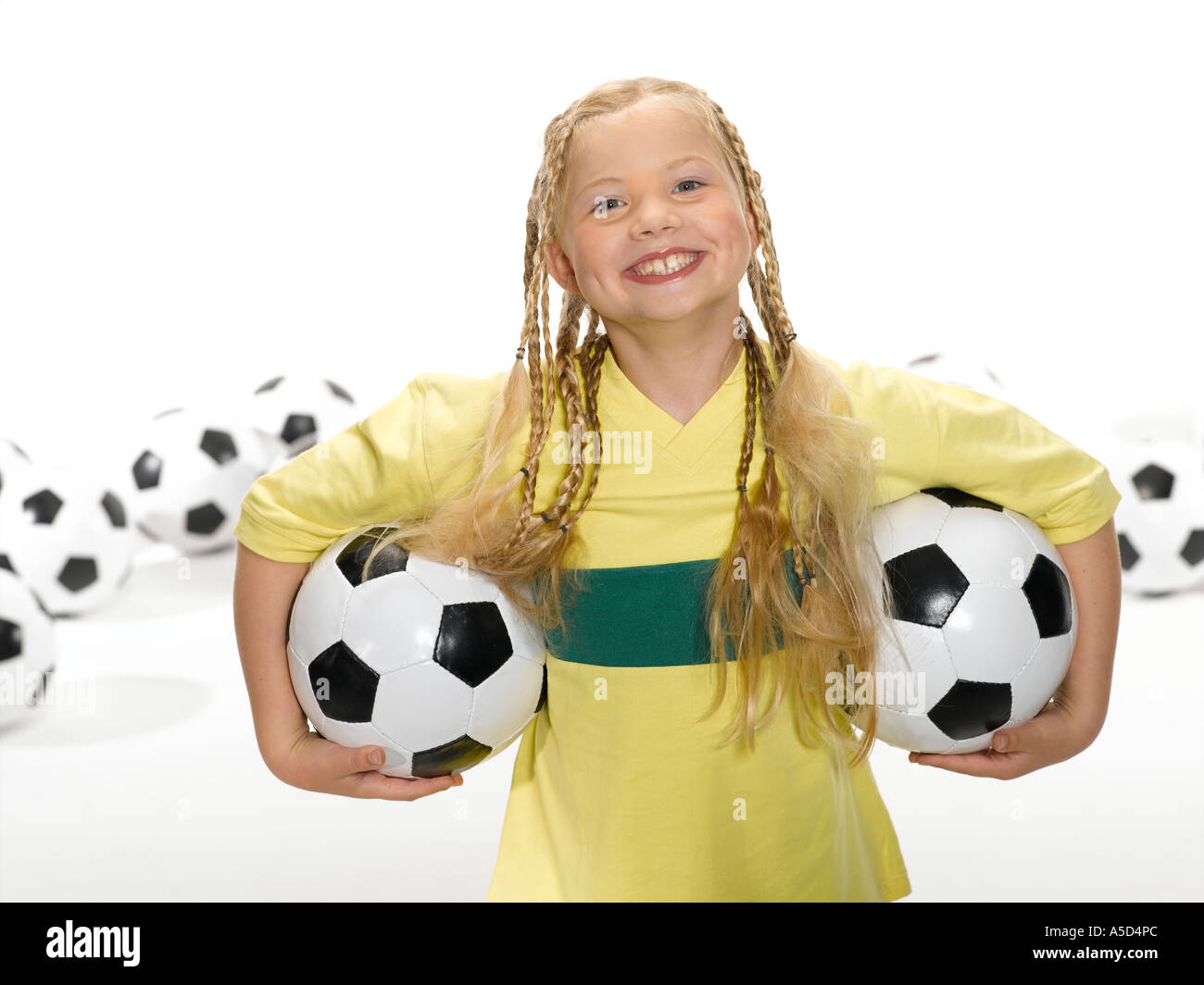 La ragazza (8-11) tenendo palla calcio sotto le armi, ritratto Foto Stock