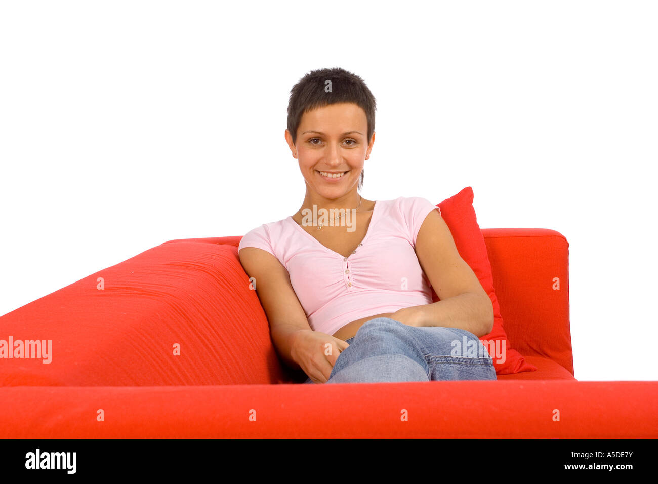 Bella donna sdraiata sul divano rosso Foto Stock