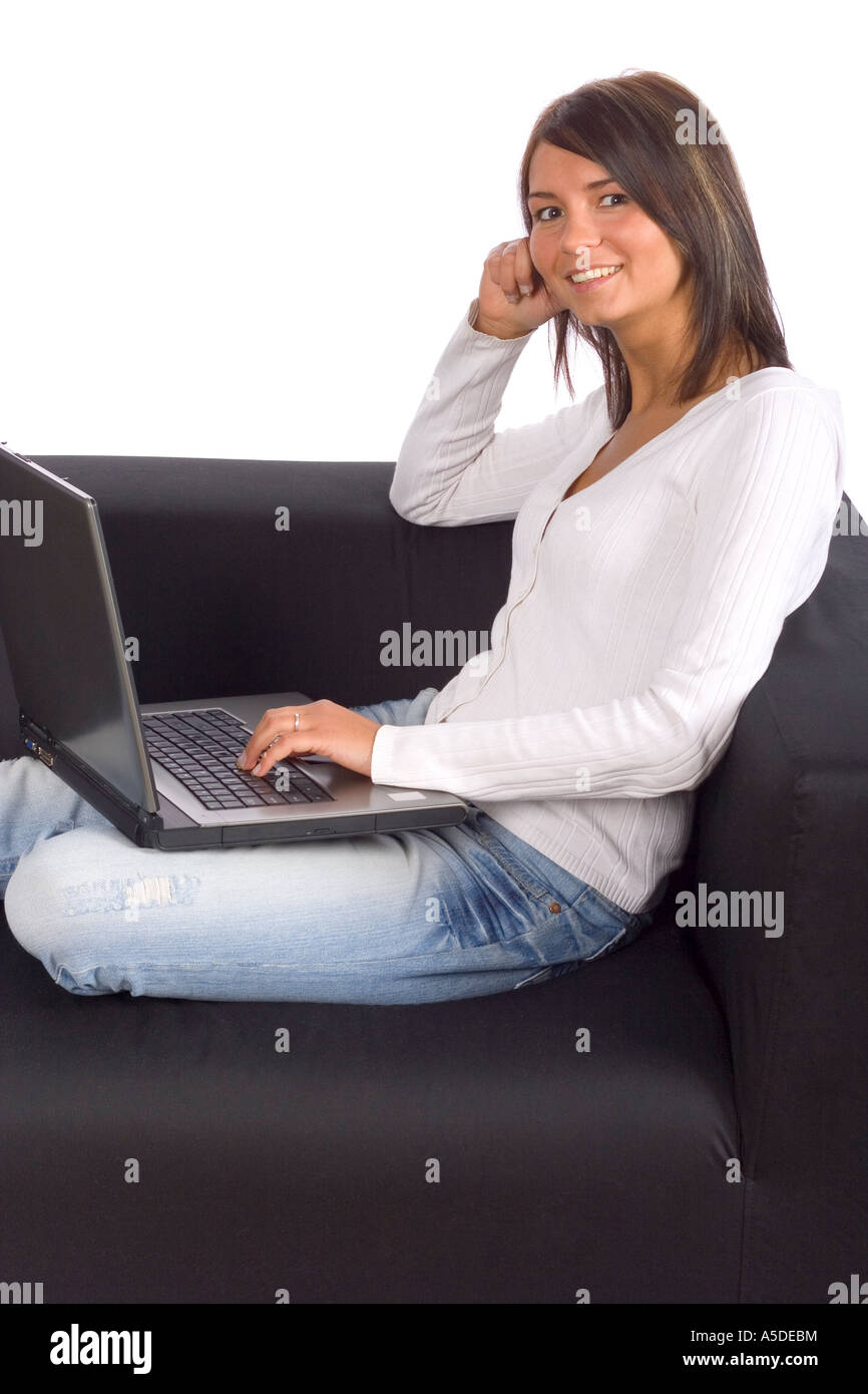 Giovane donna seduta sul divano nero portatile con sfondo bianco in studio Foto Stock